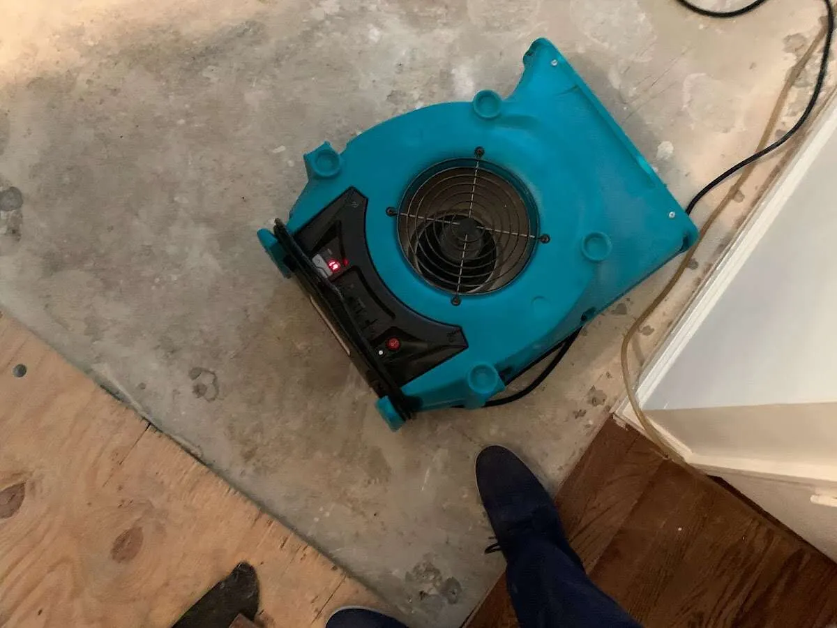 Air mover drying subfloor during Leak Detection & Repair in Bettendorf